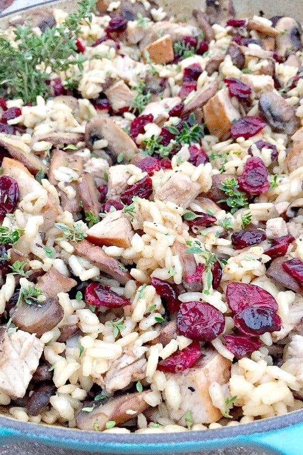 Risotto with turkey meat, mushroom and cranberry in pan.